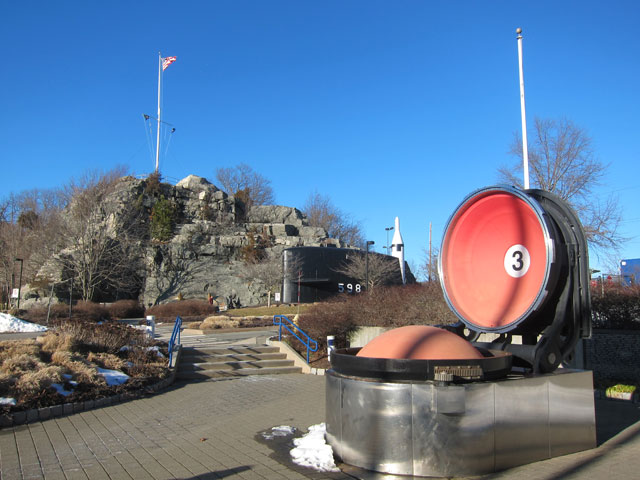 Looking from the entrance to Sub Base New London - flag on hill. Open hatch in foreground is the top of a Polaris Missile Tube.